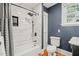 This bathroom features blue walls, a shower with white tile surround, and white toilet and sink at 304 Polk St, Raleigh, NC 27604