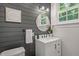 Charming powder room featuring wood plank walls, mirror, and sink with vanity at 304 Polk St, Raleigh, NC 27604