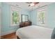 This bright bedroom has a ceiling fan, hardwood floors, light blue walls and two windows with white trim at 304 Polk St, Raleigh, NC 27604