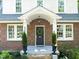 Close up of entryway with wreath on the door, brickwork, and decorative planters at 304 Polk St, Raleigh, NC 27604