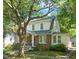 Charming two-story home with brick facade, lush landscaping, and mature trees at 304 Polk St, Raleigh, NC 27604