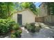 Detached garage with brick path surrounded by potted plants and flowers at 304 Polk St, Raleigh, NC 27604