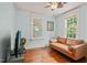 This cozy living room features hardwood floors, light blue walls, two windows and a tan leather sofa at 304 Polk St, Raleigh, NC 27604