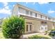 Rear exterior view of a white townhouse showcasing a patio, double doors, and well-maintained landscaping at 3147 Rapid Falls Rd, Cary, NC 27519