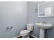 Powder room featuring blue walls, pedestal sink, and ceramic toilet at 3147 Rapid Falls Rd, Cary, NC 27519