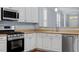 Updated kitchen features stainless steel appliances and quartz countertops at 3147 Rapid Falls Rd, Cary, NC 27519