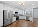 Modern kitchen with stainless steel appliances, white cabinets, and hardwood floors at 3147 Rapid Falls Rd, Cary, NC 27519