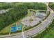 An aerial view of community amenities, including a pool, ponds, and tennis and basketball courts, surrounded by lush greenery at 3194 Retama Run, New Hill, NC 27562