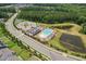 An aerial view highlighting the community pool and recreational facilities nestled between ponds and a picturesque neighborhood setting at 3194 Retama Run, New Hill, NC 27562
