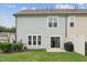 View of fenced backyard with patio and grill, leading into house with sliding glass door at 3194 Retama Run, New Hill, NC 27562