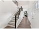 Inviting foyer with hardwood floors, a staircase with modern railings, and bright natural light at 3194 Retama Run, New Hill, NC 27562