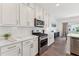 Modern kitchen features stainless steel appliances, white cabinets and light quartz countertops at 3194 Retama Run, New Hill, NC 27562