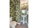 Stylish powder room featuring a pedestal sink and vibrant leaf-themed wallpaper at 3194 Retama Run, New Hill, NC 27562