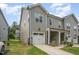 Side view of a two-story townhome with attached garage, covered porch, and green lawn at 321 Conrad Ln, Wake Forest, NC 27587