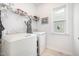 Well-lit laundry room with full-size washer and dryer, shelving, and a window at 321 Conrad Ln, Wake Forest, NC 27587