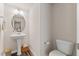 Cozy powder room with pedestal sink, decorative mirror, and toilet at 3224 Star Gazing Ln, Durham, NC 27703