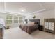 Bright primary bedroom with plush carpet and tray ceilings and many windows at 3224 Star Gazing Ln, Durham, NC 27703