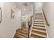 Hallway featuring hardwood floors, a staircase with wood railings, and views of the open-concept kitchen at 3224 Star Gazing Ln, Durham, NC 27703
