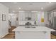 Modern open-concept kitchen with gray cabinetry, stainless steel appliances, and a spacious white island at 3224 Star Gazing Ln, Durham, NC 27703