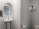Simple half bath featuring a pedestal sink, oval mirror, and toilet at 3292 Longpine Rd, Burlington, NC 27215