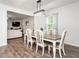 Open dining area with wood floors, stylish light fixture, flowing into the living room at 3292 Longpine Rd, Burlington, NC 27215