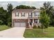 Two-story home with stone and siding, attached two-car garage, green lawn, and neatly trimmed shrubs at 3292 Longpine Rd, Burlington, NC 27215