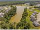Aerial view showcasing a serene lake surrounded by lush greenery and charming neighborhood homes at 3417 Cardinal Lake Dr, Durham, NC 27704