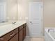 Bright bathroom featuring a modern vanity, a large mirror, and a soaking tub at 3417 Cardinal Lake Dr, Durham, NC 27704