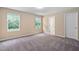 Comfortable bedroom with soft carpet, neutral walls, and ample natural light from two windows at 3417 Cardinal Lake Dr, Durham, NC 27704