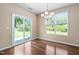 Bright dining area featuring wood floors, modern chandelier, and sliding glass doors to the backyard at 3417 Cardinal Lake Dr, Durham, NC 27704