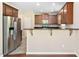 Spacious kitchen with stainless steel refrigerator, wood cabinets, granite countertops, and a breakfast bar at 3417 Cardinal Lake Dr, Durham, NC 27704