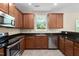 Well-equipped kitchen featuring stainless steel appliances, wood cabinets, and granite countertops at 3417 Cardinal Lake Dr, Durham, NC 27704