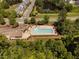 Aerial view of a sparkling community pool with lounge chairs and umbrellas surrounded by lush trees at 3417 Cardinal Lake Dr, Durham, NC 27704