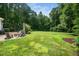 Expansive backyard with lush green lawn, mature trees, and a cozy outdoor patio area perfect for relaxation at 3748 Westbury Lake Dr, Raleigh, NC 27603