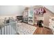 Bright Bedroom featuring a crib, changing station, and colorful polka dot rug at 3748 Westbury Lake Dr, Raleigh, NC 27603