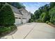 Spacious driveway leading to a three-car garage, surrounded by manicured landscaping and mature trees at 3748 Westbury Lake Dr, Raleigh, NC 27603