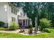 Home exterior featuring a screened porch, brick patio with seating, and lush landscaping at 3748 Westbury Lake Dr, Raleigh, NC 27603