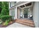 Inviting front porch with black door, neutral siding, brick accents and well-manicured landscaping at 3748 Westbury Lake Dr, Raleigh, NC 27603