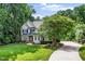 Beautiful home with a curved driveway, lush lawn, mature trees, and manicured landscaping at 3748 Westbury Lake Dr, Raleigh, NC 27603