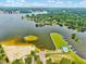 Aerial view of a serene lake with a sandy beach and a dock with boats at 39 Westover Ct, Sanford, NC 27332