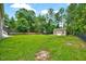 Lush backyard featuring green grass, shed, and mature trees at 39 Westover Ct, Sanford, NC 27332