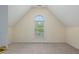 Neutral bedroom featuring a large arched window, trim, and plush carpet at 402 Bridewell Ct, Cary, NC 27518