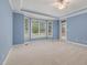 Primary bedroom with large windows offering backyard view and tray ceilings at 402 Bridewell Ct, Cary, NC 27518