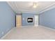 Carpeted primary bedroom features tray ceilings, fireplace, and en-suite bathroom at 402 Bridewell Ct, Cary, NC 27518