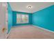 Modern bedroom with bright blue walls, plush carpet, and natural light at 402 Bridewell Ct, Cary, NC 27518