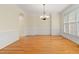 Traditional dining room with hardwood floors, wainscoting, chandelier, and ample natural light at 402 Bridewell Ct, Cary, NC 27518