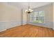 Bright dining room with a chandelier, wainscoting, and large windows at 402 Bridewell Ct, Cary, NC 27518