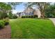Brick home featuring a lush green lawn and mature shade trees at 402 Bridewell Ct, Cary, NC 27518