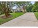 Brick home with a well-manicured lawn, mature trees, and a long driveway at 402 Bridewell Ct, Cary, NC 27518