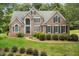 Traditional brick home featuring a manicured lawn, lush landscaping and eye-catching architectural details at 402 Bridewell Ct, Cary, NC 27518